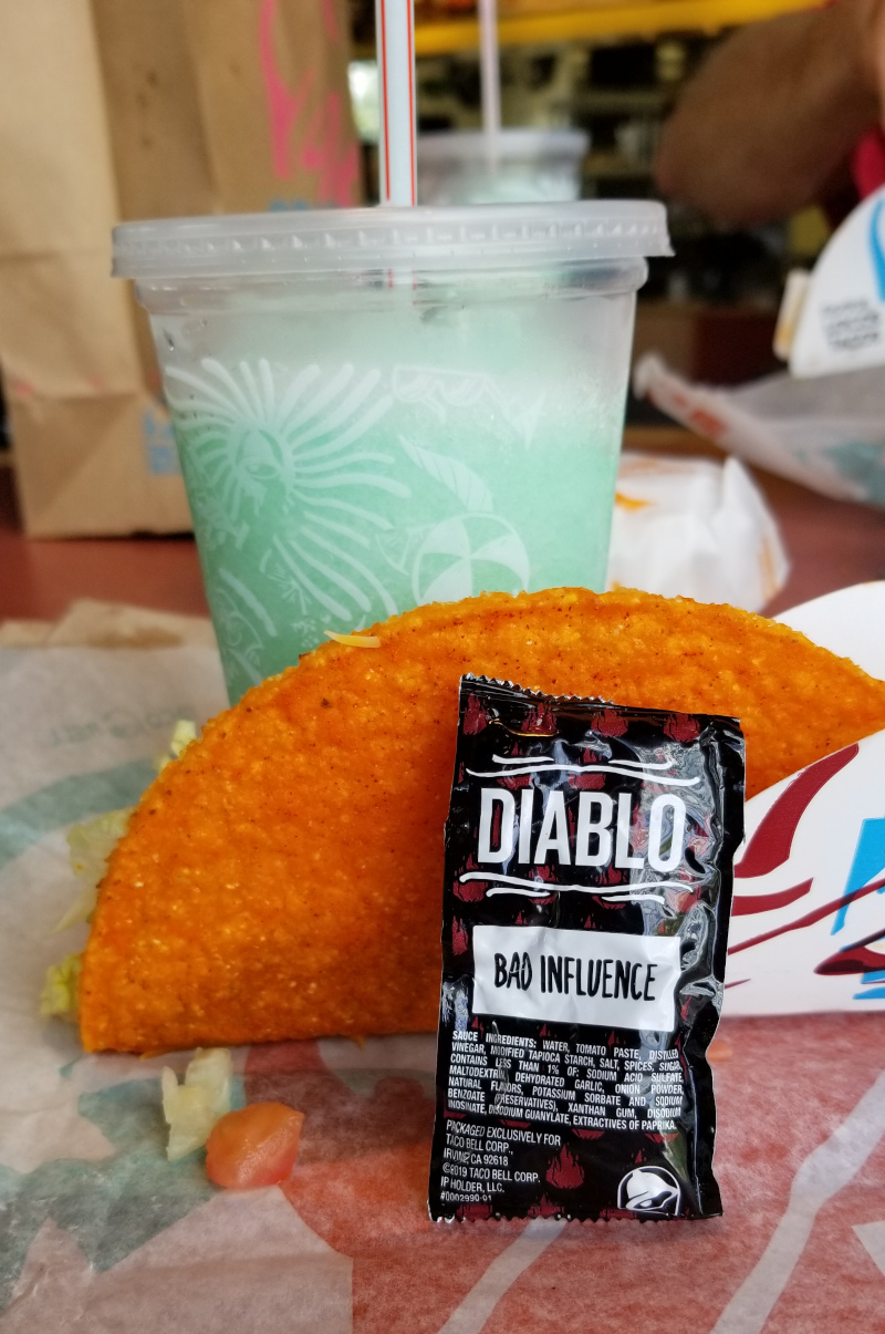This is a taco bell taco, hot sauce, and Baja Blast Freeze.